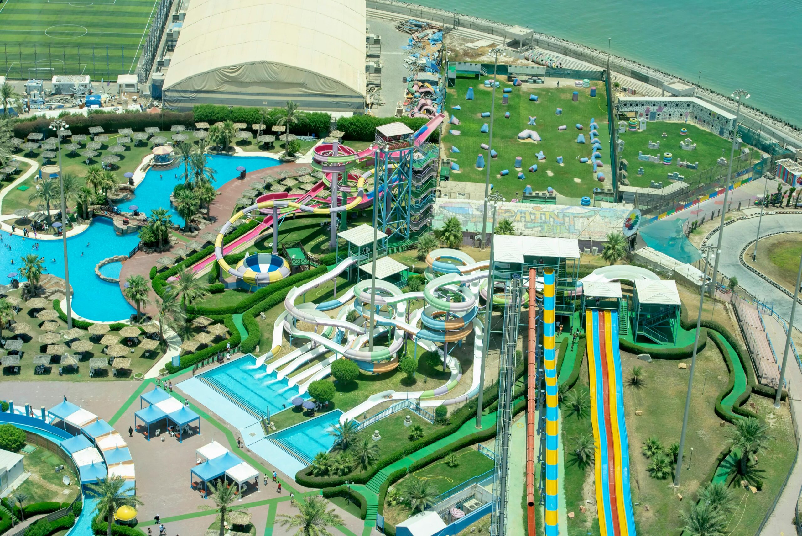 Capture the excitement of a vibrant water park from above, showcasing colorful slides and pools.